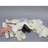 Two pairs of infants cream silk shoes with ribbon decoration and a pair of black leather shoes