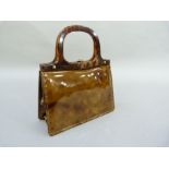 A tortoiseshell effect patent leather handbag retailed by Harrods, London, with faux shell frame and