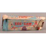 A Prestyn Toys Ltd clockwork printed tin plate see-saw, 30cm wide approx, in original box (box af)