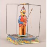 A Vintage tin plate clockwork and inertia Fishing Clown toy. The central revolving figure on a