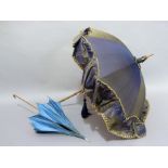 A Late Victorian blue and cream satin parasol with slender bamboo handle and turned bone tip;