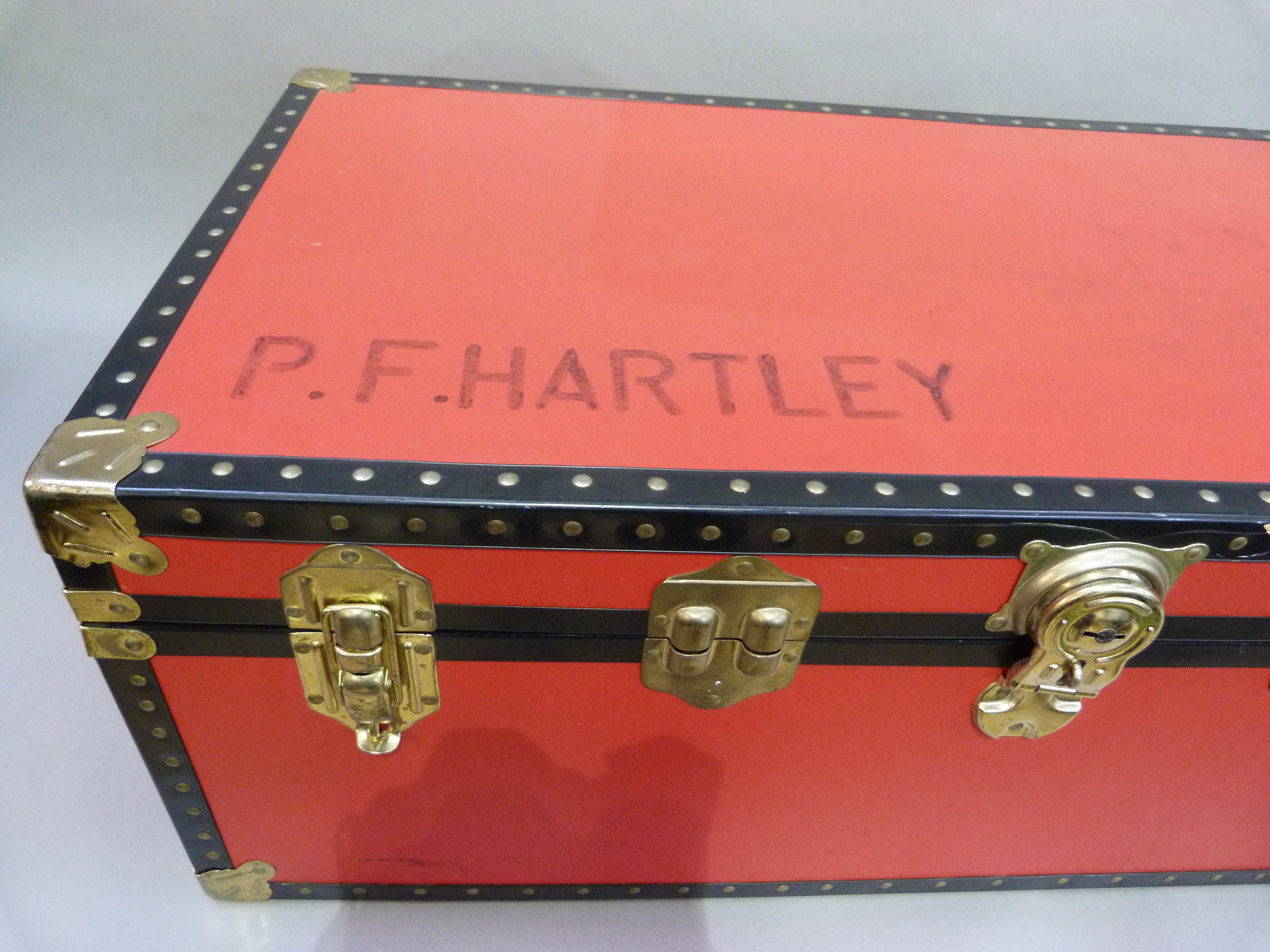 Large red and black trunk, modern, 92cm wide x 49.5cm deep x 35cm high, named P.F. Hartley