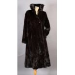 A mink coat by Maxwell Croft of London with collar and button fastening