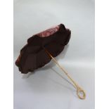 A Late Victorian aubergine satin parasol, the handle finely carved in a loop