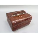 An early 20th Century crocodile skin beauty case of Gladstone style, initialled M.L.H in gilt, the