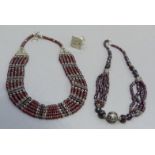 Two necklaces both multi strand facetted garnet and silver fitting of Indian origin together with