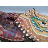 A kilim rug worked with lozenges in rust, brown, pink and mauve hues, guard stripes, fringed,