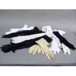 Two pairs of long length gloves in white kid, black satin and black suede; together with a pair of
