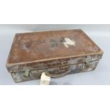 A vintage leather covered suitcase initialled J.A.S.H, remnants of luggage label 70cm x 38cm x 18cm