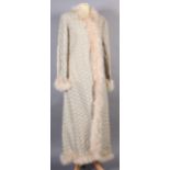 A 1960s cream flower motif full length evening coat with ostrich feather trim,