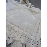 A cream cotton panelled bedspread, embroidered in white with flowering tendrils within drawn