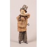 An antique printed tin plate clockwork drinking man figure, he wears a grey top hat, brown hair