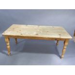 A Victorian style pine kitchen table, the rectangular 4cm thick top above turned legs, 183cm long by