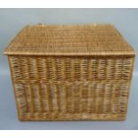 A large rectangular wicker basket with lid, two handled, 72cm wide, 52cm deep and 52cm high