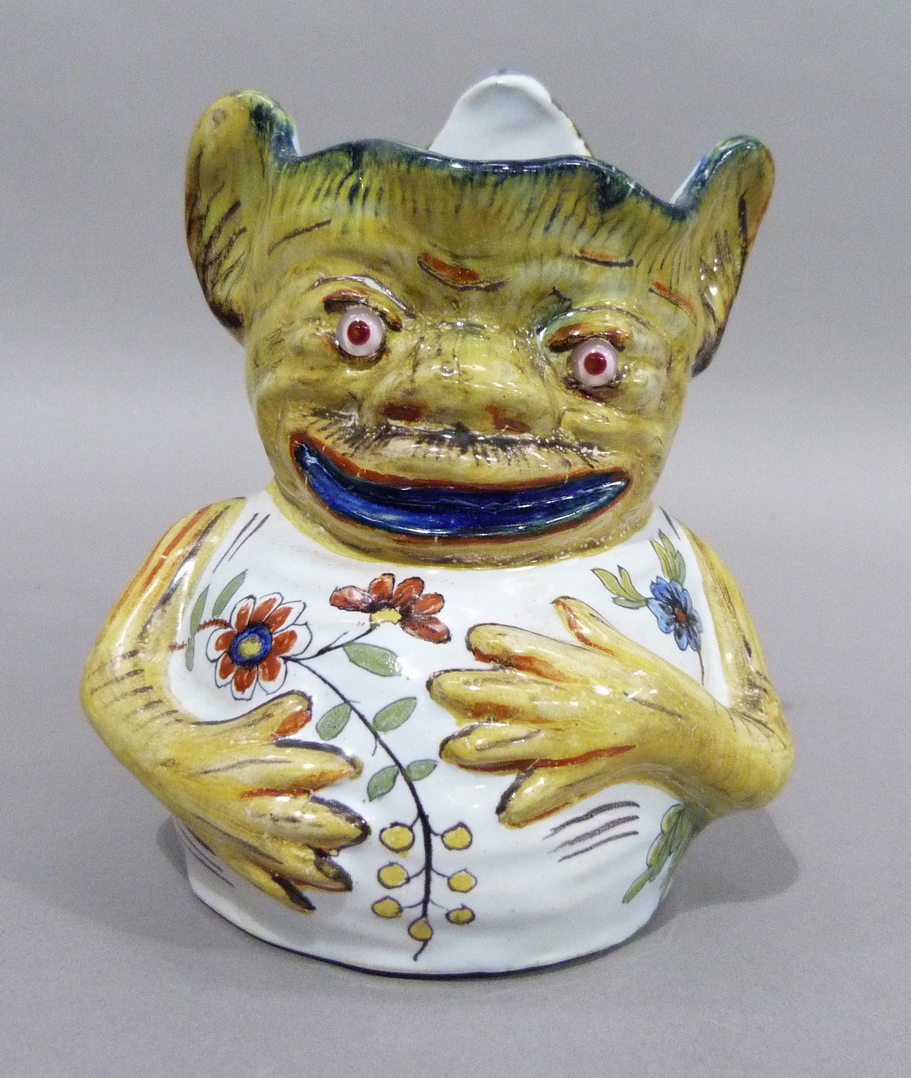 A Rouen faience grotesque face mask jug, marked to underside, 15cm