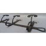 A modern wrought iron three branch wall mounted coat hook with trefoil and heart pierced back
