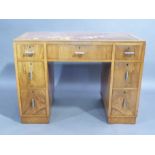 An Art Deco walnut veneered twin pedestal desk the top inset with brown tooled leather writing