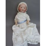 An Armand Marseille bisque headed bebe doll having blue sleeping eyes, open mouthed with two