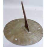 A reproduction brass sundial engraved with a skull, a scythe and the legend 'as the long hours so
