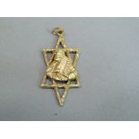 A Star of David pendant, pierced and textured with an applied relief of Moses carrying the Ten