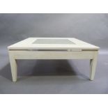 A cream painted wooden coffee table, square shape with lattice pierced centre, square tapered