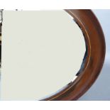 An Edwardian mahogany oval wall mirror, the cavetto moulded frame with strung edge, bevelled