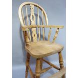 A reproduction beech Childs high chair of Windsor style with pierced splat, saddled seat on tall
