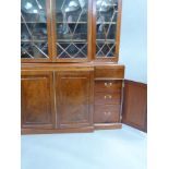 A reproduction mahogany break front bookcase in George III style, the top with flared cornice,