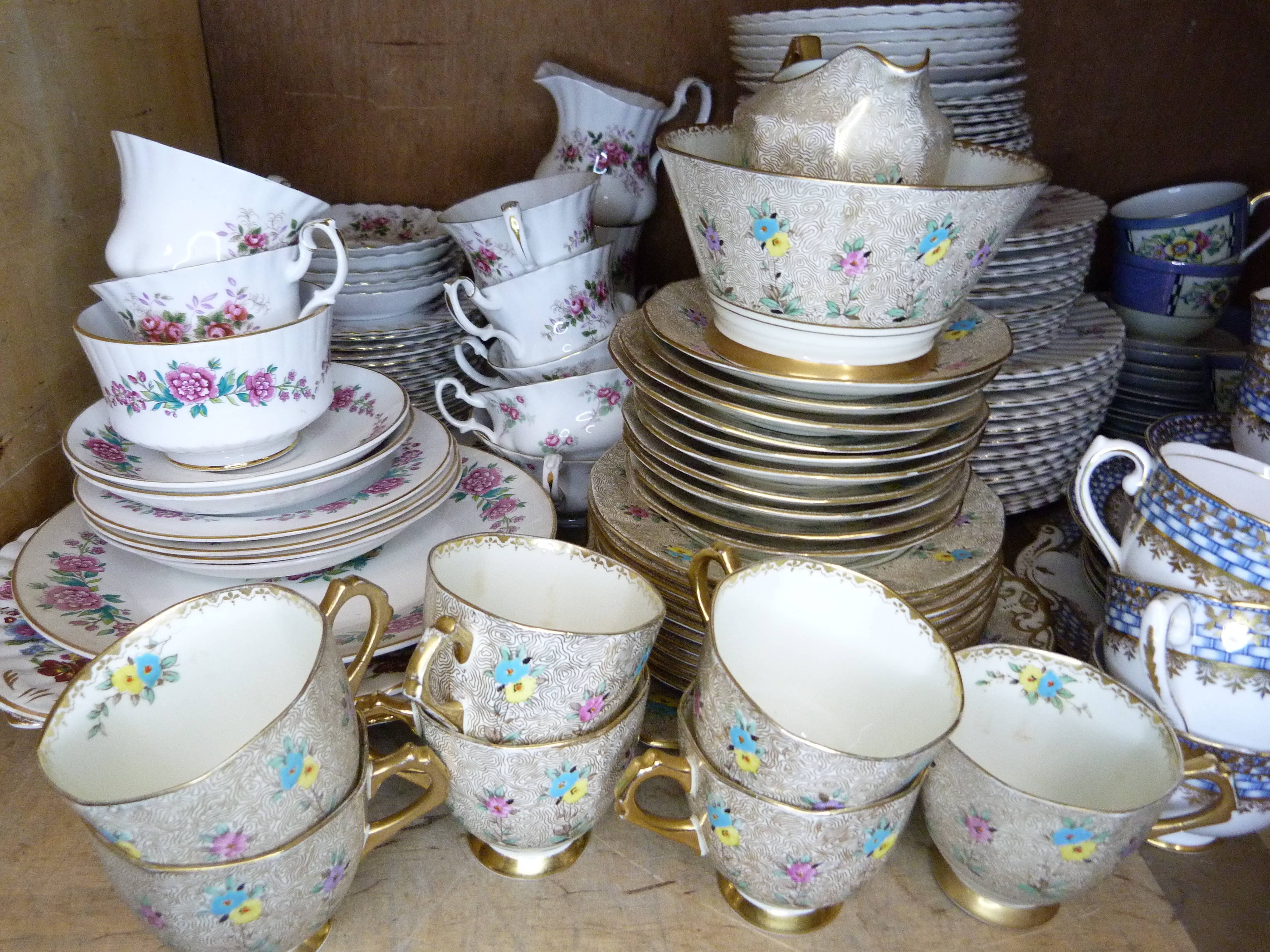 A quantity of rosebud decorated dinner and tea ware, an art deco part service, a Tuscan china gilt