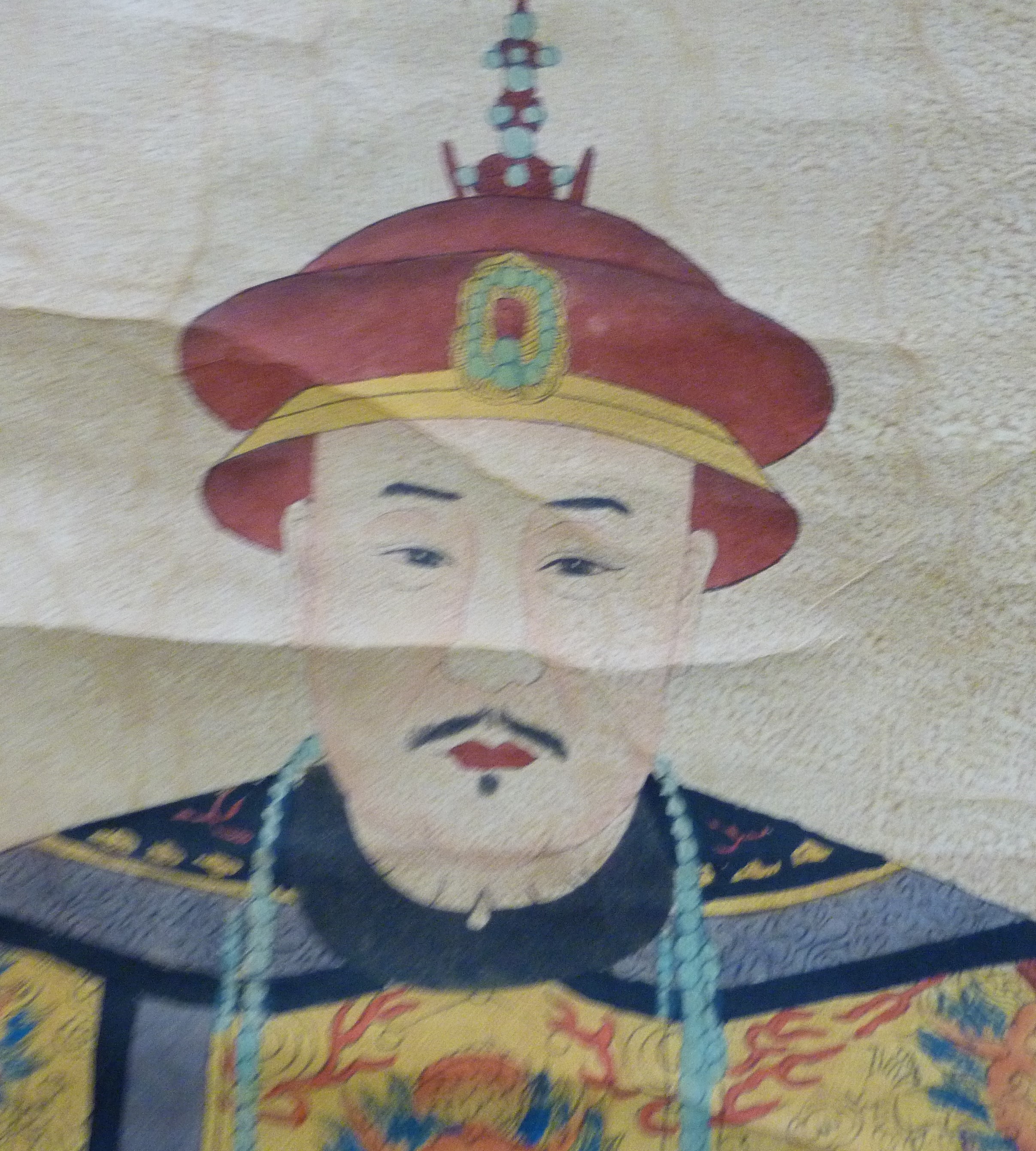 A Japanese scroll printed and painted with a portrait of an Emperor in fine robes
