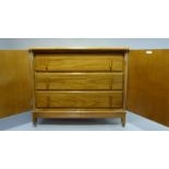 An art deco style oak cupboard, the rectangular top with applied ovolo moulded lip, the pair of