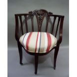 A late Victorian mahogany framed tub chair with palmette headed vertical rails flanking a waisted