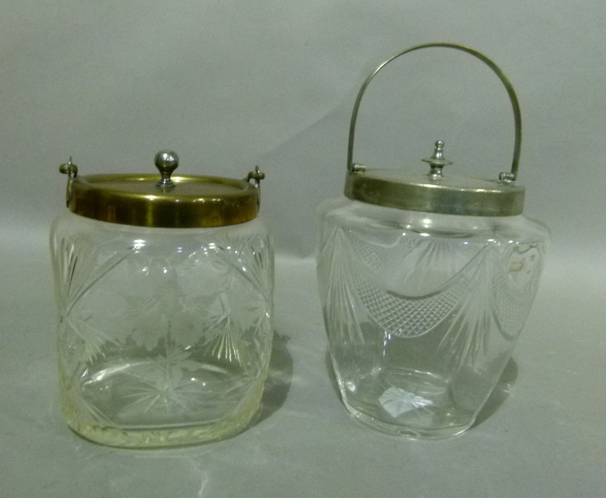 Two Edwardian glass biscuit barrels, the first of square dimpled form, cut and etched with