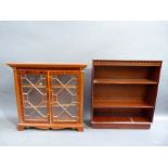 A yew veneered glazed bookcase enclosed by a pair of doors, applied moulded glazing bars on