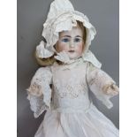 An early twentieth century bisque headed doll having fixed blue eyes, painted features, open mouth