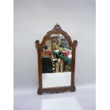 A mahogany wall mirror of arched outline with shell cresting, 77cm by 45cm`