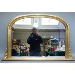 A reproduction gilt framed arched overmantle mirror in Victorian style, the plate within moulded