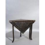 An oak drop leaf triangular table with leaf folding at the back the top carved with flowing