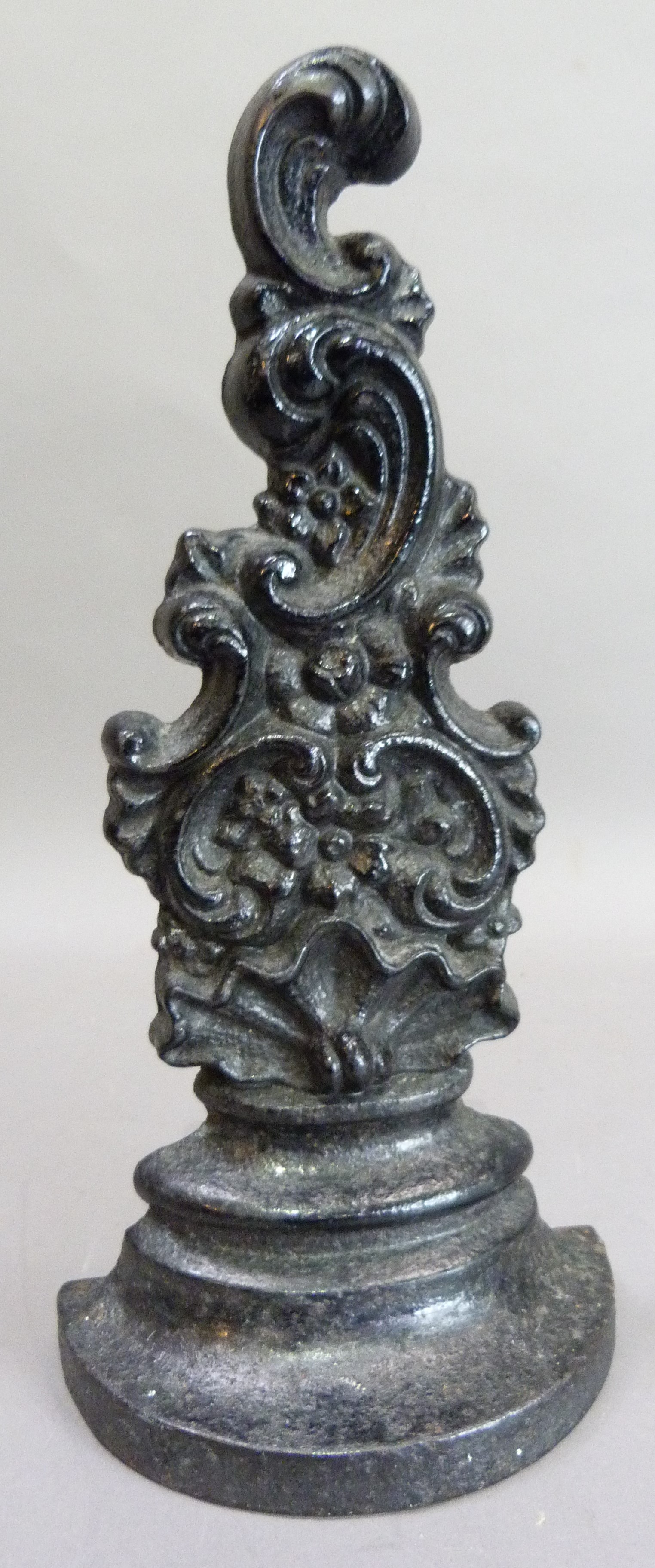A Victorian cast iron doorstop of shell and c scroll form, 34cm high