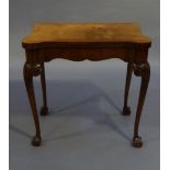 A walnut card table, the rectangular top with serpentine front and rounded corners, cross banded,