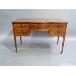 An Edwardian Sheraton revival dressing table or desk, the top with bowed centre fitted one long