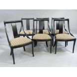 A set of six ebonised spoon back dining chairs with broad splats to the backs, upholstered seat sand