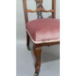 A pair of late Victorian walnut bedroom or salon chairs with ornate carved cresting rails above