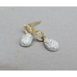 A pair of diamond cluster earrings in 18ct yellow gold, each set with pear shaped drop with small