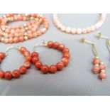 A collection of coral bead jewellery including a necklace, bracelet and two pairs of earrings with