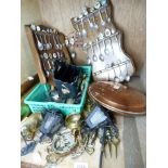 A small quantity of silver plated commemorative spoons contained within shaped oak racks, together