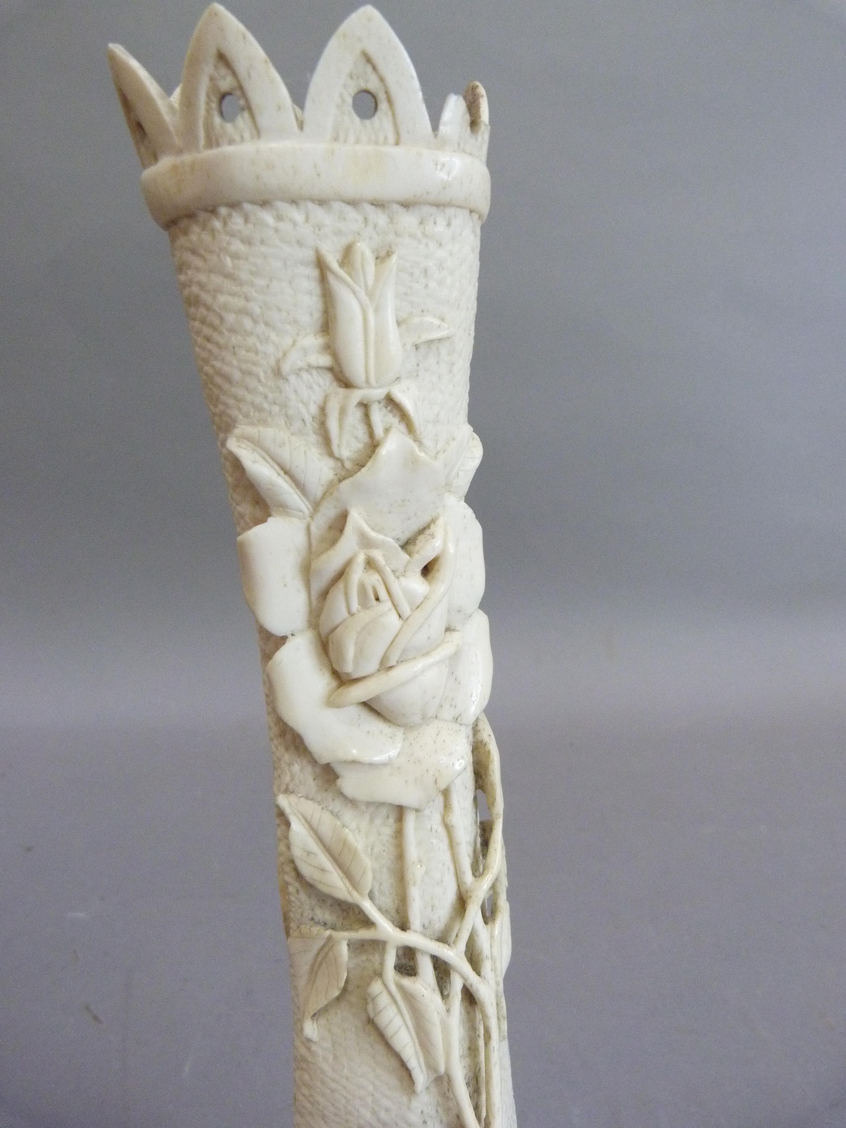 A bone carving of a castle turret with rose briar, the reverse with cartouche and Isle of Man