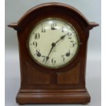 An early 20th century mahogany mantel clock of domed outline having a cream dial with black Arabic