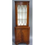 A reproduction mahogany glazed standing corner cupboard in George III style, the dentil moulded
