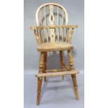 A child's reproduction beech high chair of Windsor style with pierced splat, saddled seat on tall
